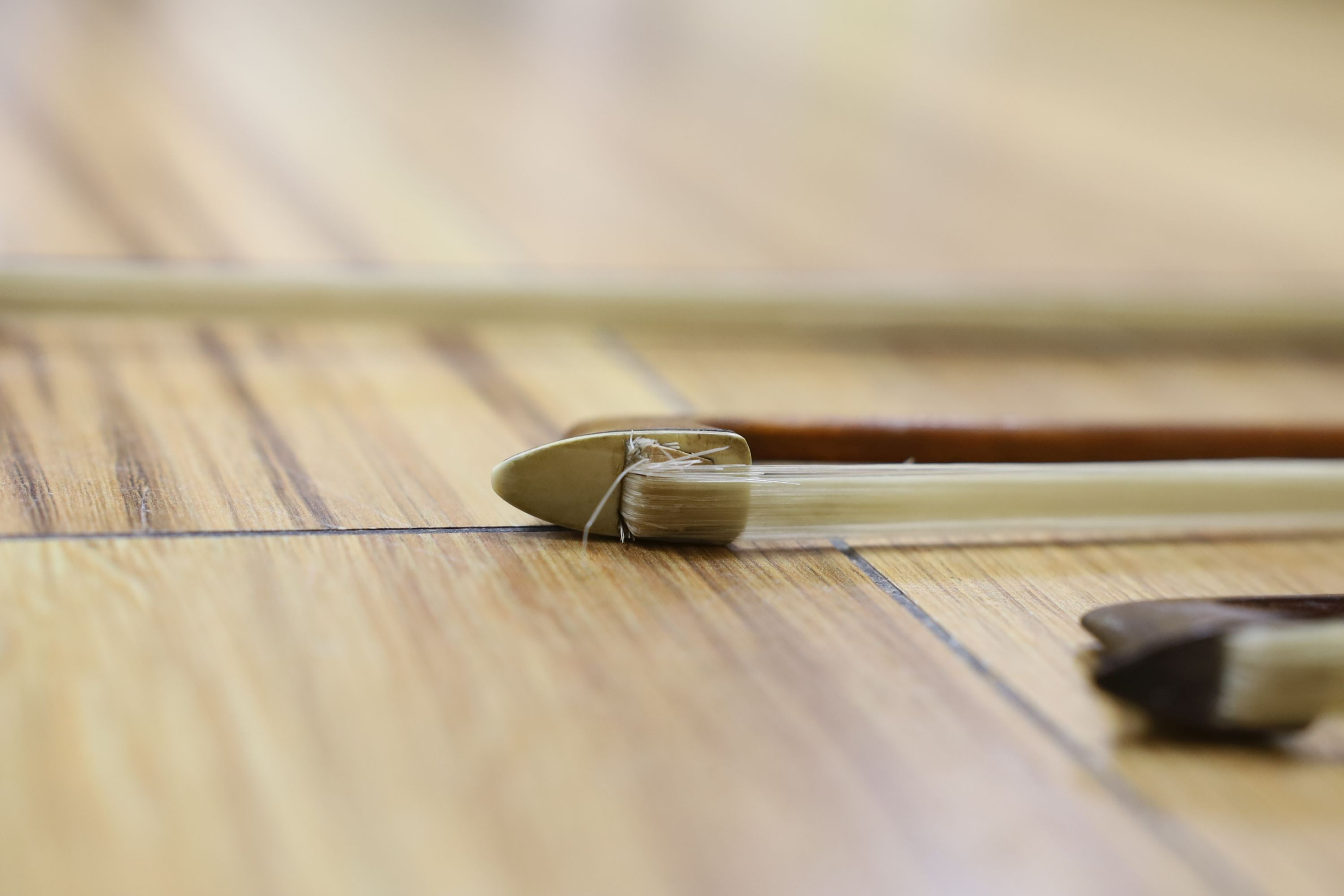 Three nickel mounted violin bows, one stamped R. R. Shields, two with ivory veneered tip - longest 75cm